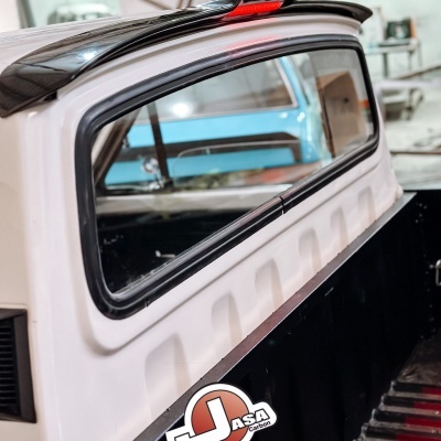 Vidro traseiro de carrinha branca com spoiler preto e luz de travagem vermelha, com logo JASA Carbon e texto www.JasaCarbon.com