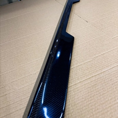 Peça longa de fibra de carbono com acabamento brilhante sobre cartão