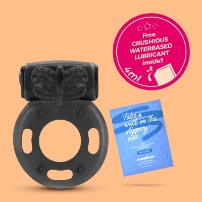 anel preto texturizado com pacote azul e selo rosa em fundo bege