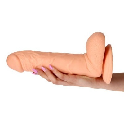 Dildo cor pele com detalhes realistas e base circular segurado por uma mão