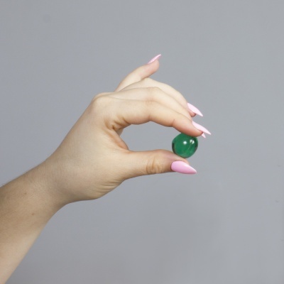Mão segurando esfera verde translúcida