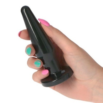 Objeto cónico preto segurado por uma mão com unhas pintadas de rosa e verde