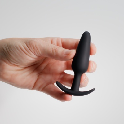 Plug anal preto de silicone segurado por mão feminina