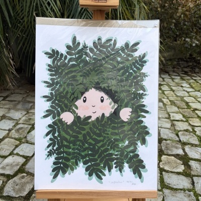 Ilustração de personagem entre folhas verdes exibida em cavalete de madeira em ambiente exterior.