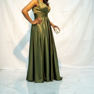 Mulher a usar vestido verde de festa comprido e segurando clutch prateada