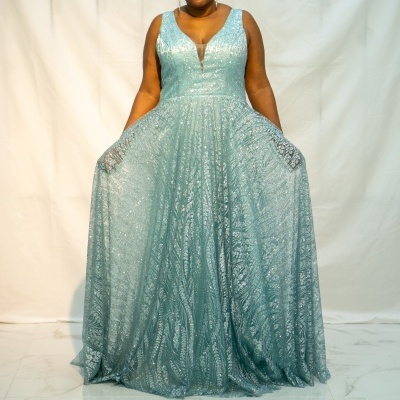 Vestido azul claro com brilho e padrão, decote em V, usado por mulher de pé.