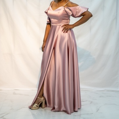 Vestido comprido rosa de cetim com alças finas e fenda, em fundo branco.