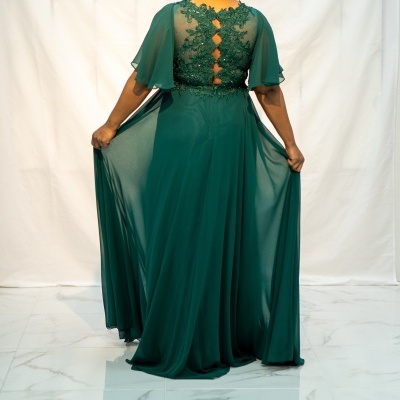 Vestido longo verde com renda e detalhes bordados, visto de costas, fundo branco