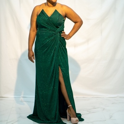 Vestido verde cintilante com fenda lateral usado por mulher.