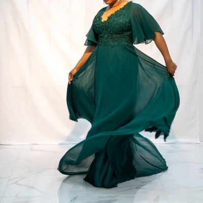 Vestido longo verde escuro com manga esvoaçante em estúdio.