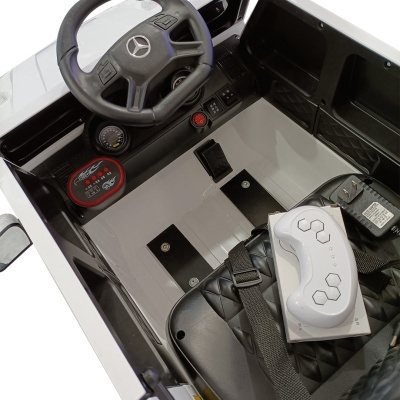 Interior de carro elétrico infantil branco com volante preto Mercedes-Benz e controle remoto