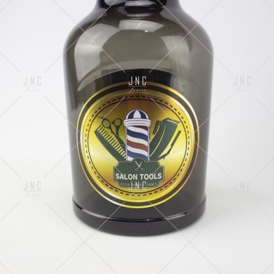 Garrafa de vidro fumado com rótulo dourado e ferramentas de salão de cabeleireiro