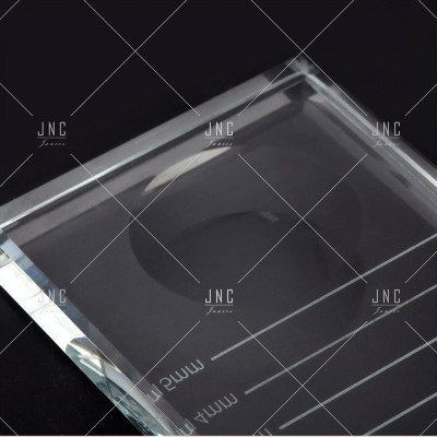 Prisma de vidro transparente com bordas facetadas sobre fundo preto