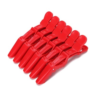 Seis pregadores de roupa vermelhos em plástico sobre fundo branco.