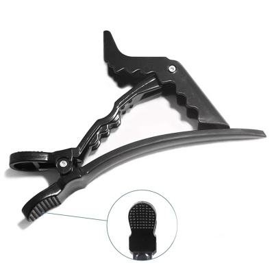 Grampo de cabelo preto com estrutura articulada e dentes ondulados