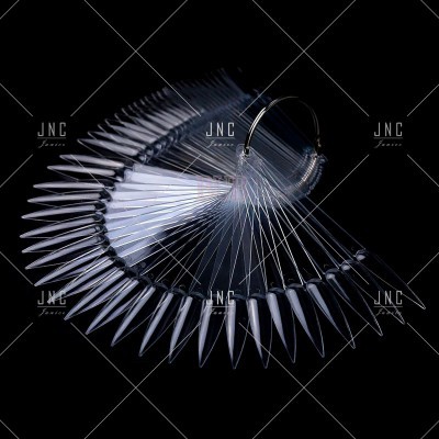 Amostras de unhas artificiais transparentes em formato pontiagudo num leque com anel metálico.