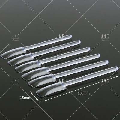 Seis espátulas plásticas transparentes sobre fundo preto