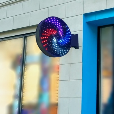 Sinal LED circular colorido montado em parede cinzenta junto a porta azul