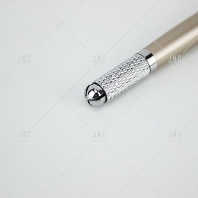 Detalhe da ponta e parte inferior de uma caneta dourada com metal prateado texturizado