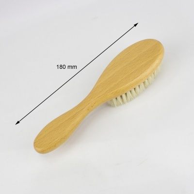 Escova de cabelo com cabo de madeira clara e cerdas brancas sobre fundo branco