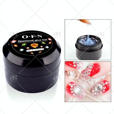 Frasco preto de gel cola Diamond Glue Gel O-F-N, pincel a aplicar gel translúcido, unhas vermelhas com decoração de pedras