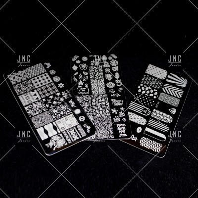 Placas metálicas para carimbos de unhas com padrões decorativos brancos sobre fundo preto