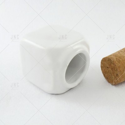 Cubinho branco de cerâmica com orifício e rolha de cortiça ao lado