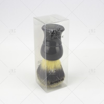 Pincel de barbear com cabo preto e cerdas claras em embalagem transparente