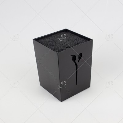 Caixa preta quadrada com tampa em fundo branco