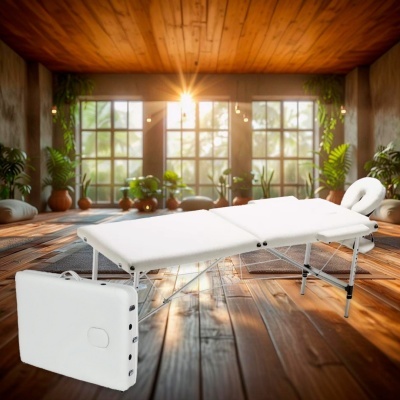 Cama de massagem portátil branca com suporte para cabeça e bolsa de transporte num ambiente de madeira com plantas