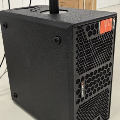 Coluna preta com grelha hexagonal e texto SOUND V300A no chão branco