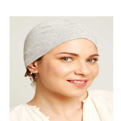 Mulher com lenço cinzento claro na cabeça e brincos coloridos