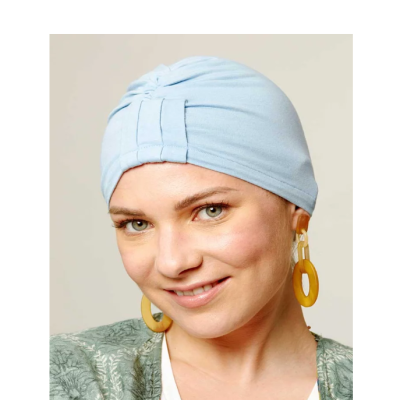 Mulher usando touca azul clara e brincos amarelos grandes