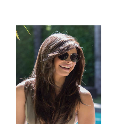 Mulher com óculos de sol e cabelo castanho longo em ambiente exterior