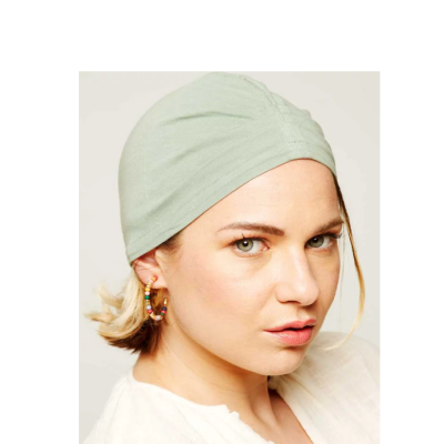 Mulher com touca verde clara e brincos de argola coloridos