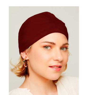 Mulher com lenço bordô, brincos coloridos e blusa branca