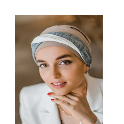 Mulher com lenço bege, cinza e branco na cabeça e casaco branco