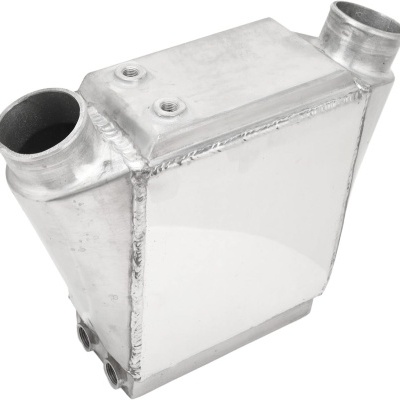 Intercooler metálico prateado com tubos cilíndricos e soldaduras visíveis