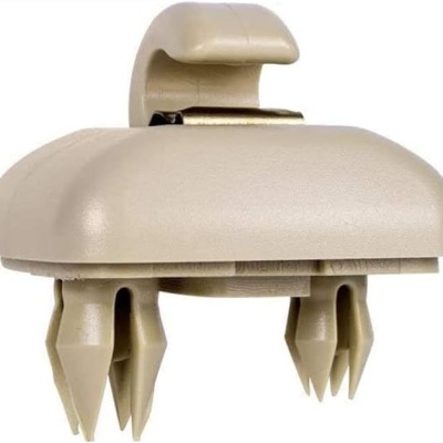 Clipe universal de fixação automóvel em plástico bege com presilhas.