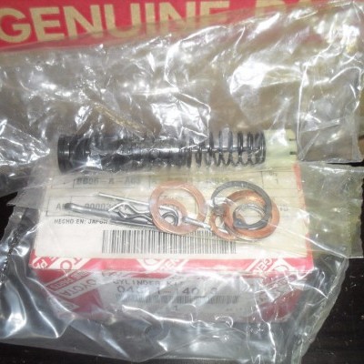 Peças automotivas embaladas com mola e arruelas sobre caixa com texto