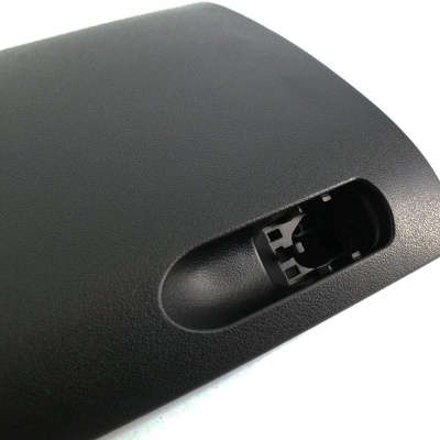 Peça preta de plástico texturizado com recorte retangular e encaixe