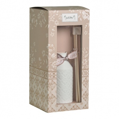 Difusor de ambiente branco em vidro com relevo e fita floral, dentro de embalagem decorativa bege com padrão floral