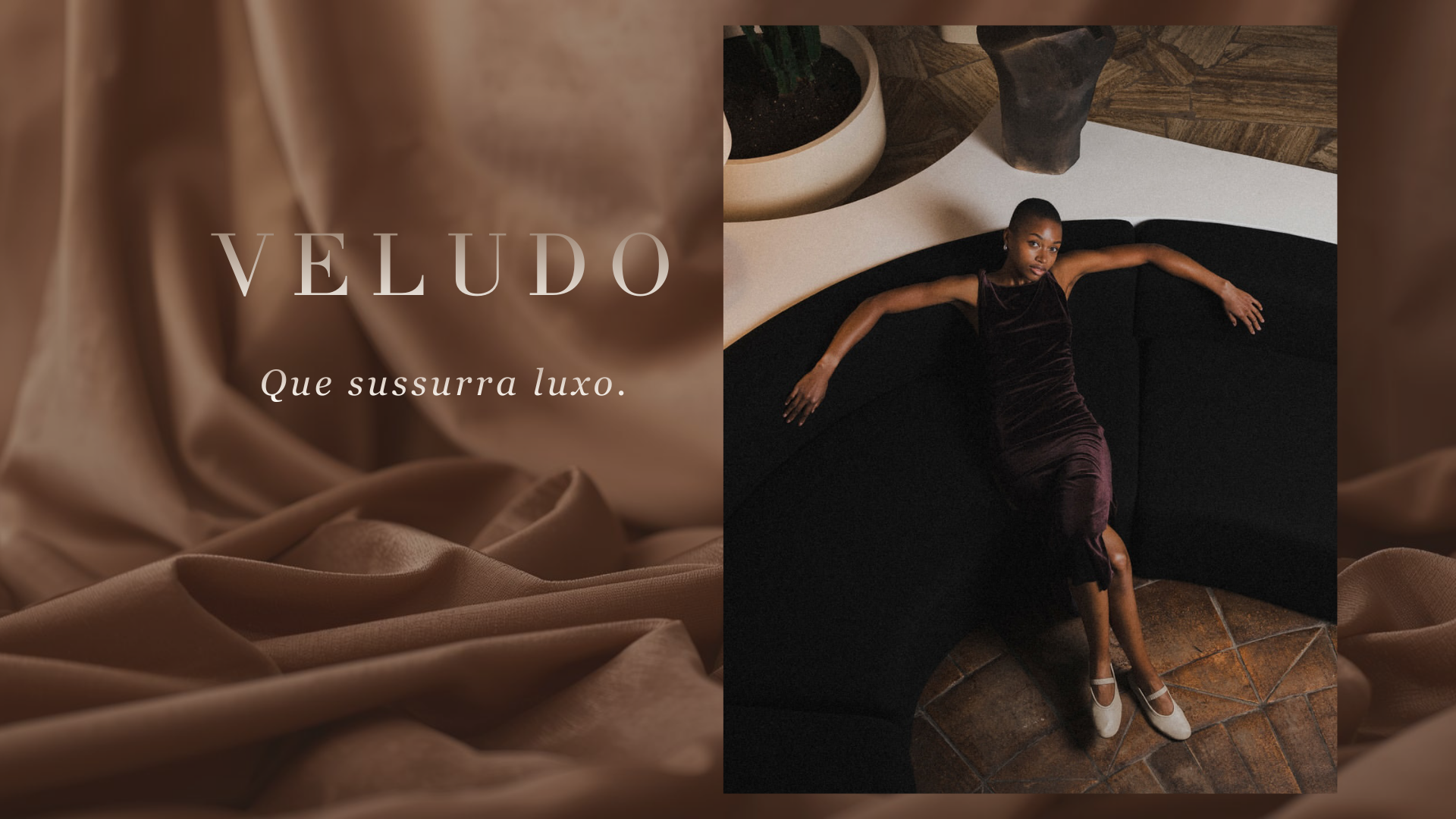 Mulher sentada num sofá preto curvo a usar vestido de veludo bordô