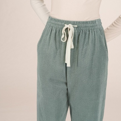 Calças de tecido canelado verde azulado com cordão branco e camisola branca