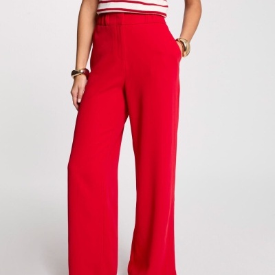 Calças vermelhas largas usadas com t-shirt de riscas vermelhas e brancas, sapatos brancos.