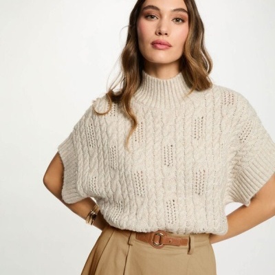 Mulher a usar camisola de malha bege com padrão de tranças