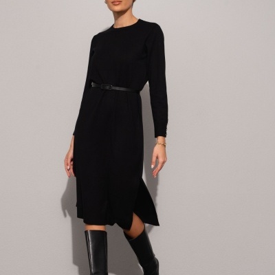 Mulher a usar vestido preto de malha com cinto e botas pretas de cano alto