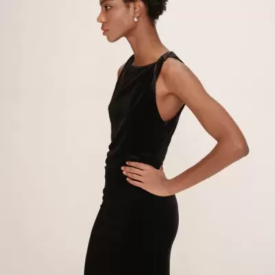 Mulher com vestido preto de veludo e brinco prata