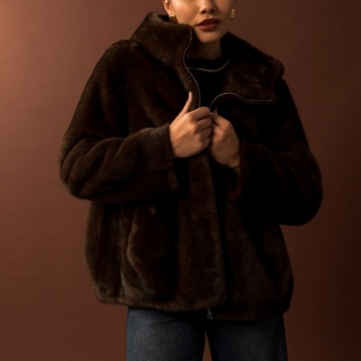 Mulher a usar casaco pelo sintético castanho escuro com fecho