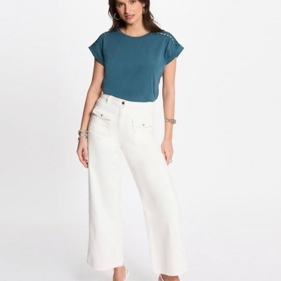 Mulher com t-shirt azul e calças brancas de corte largo